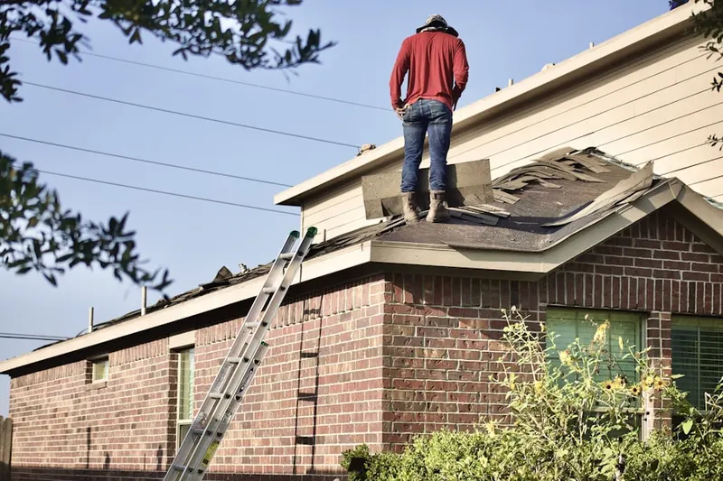 Professional roofer working on a residential roof in Sheridan